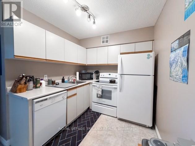 A kitchen with white appliances and cabinets.