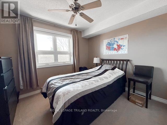 A bedroom with a bed, chair, and window.
