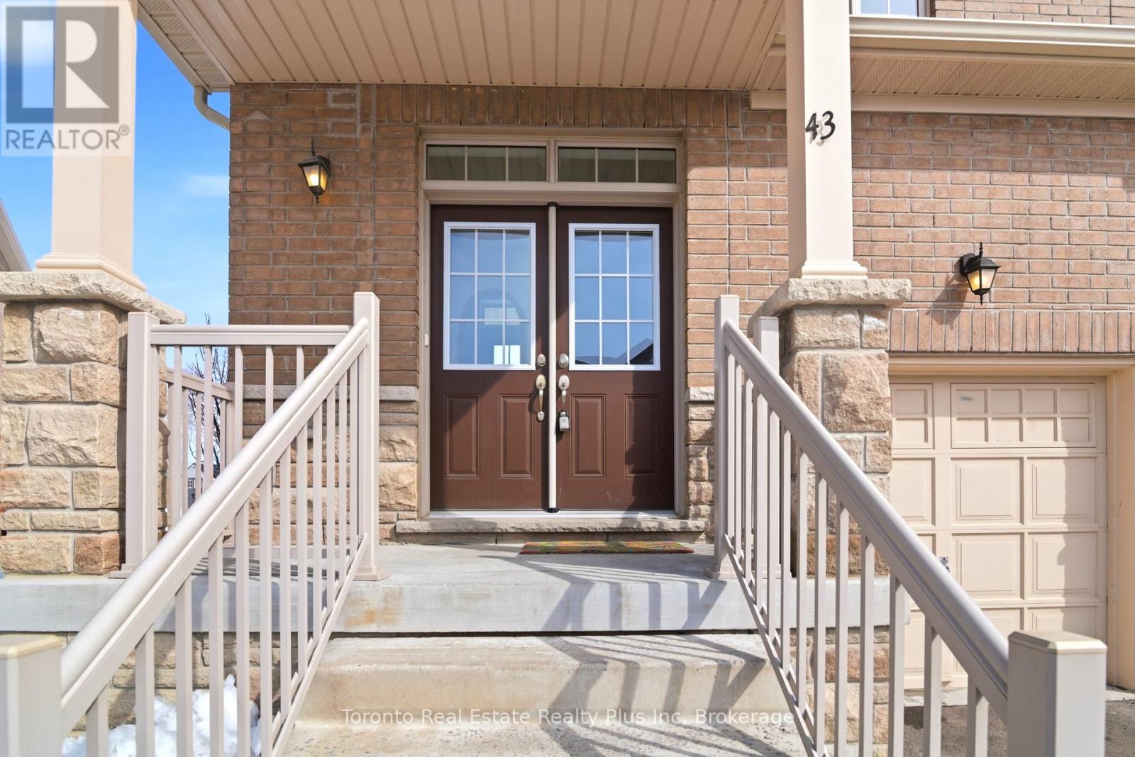 A house with a brown door and a number 43 on the wall.