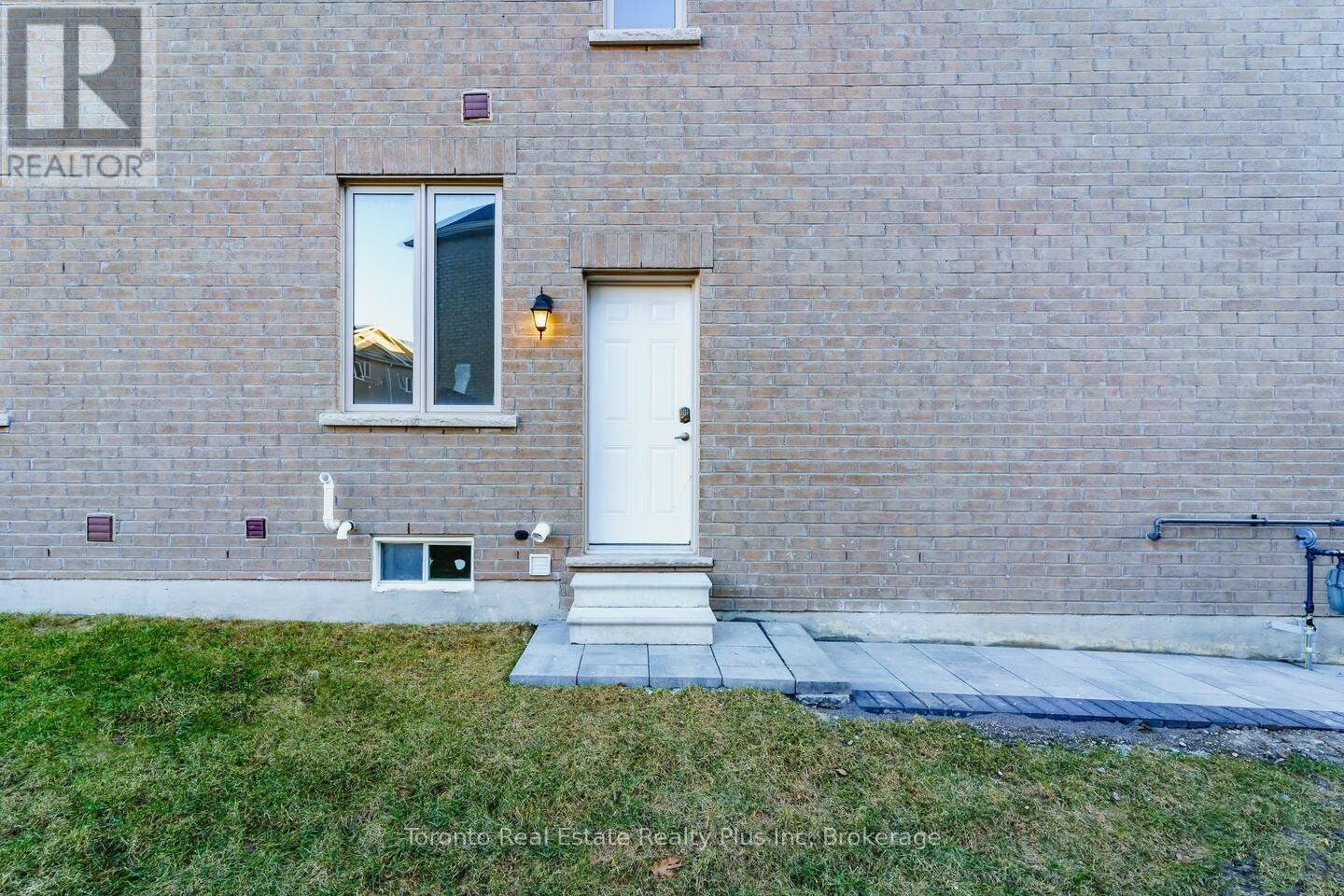 A brick building with a white door and a window with a reflection of a building.