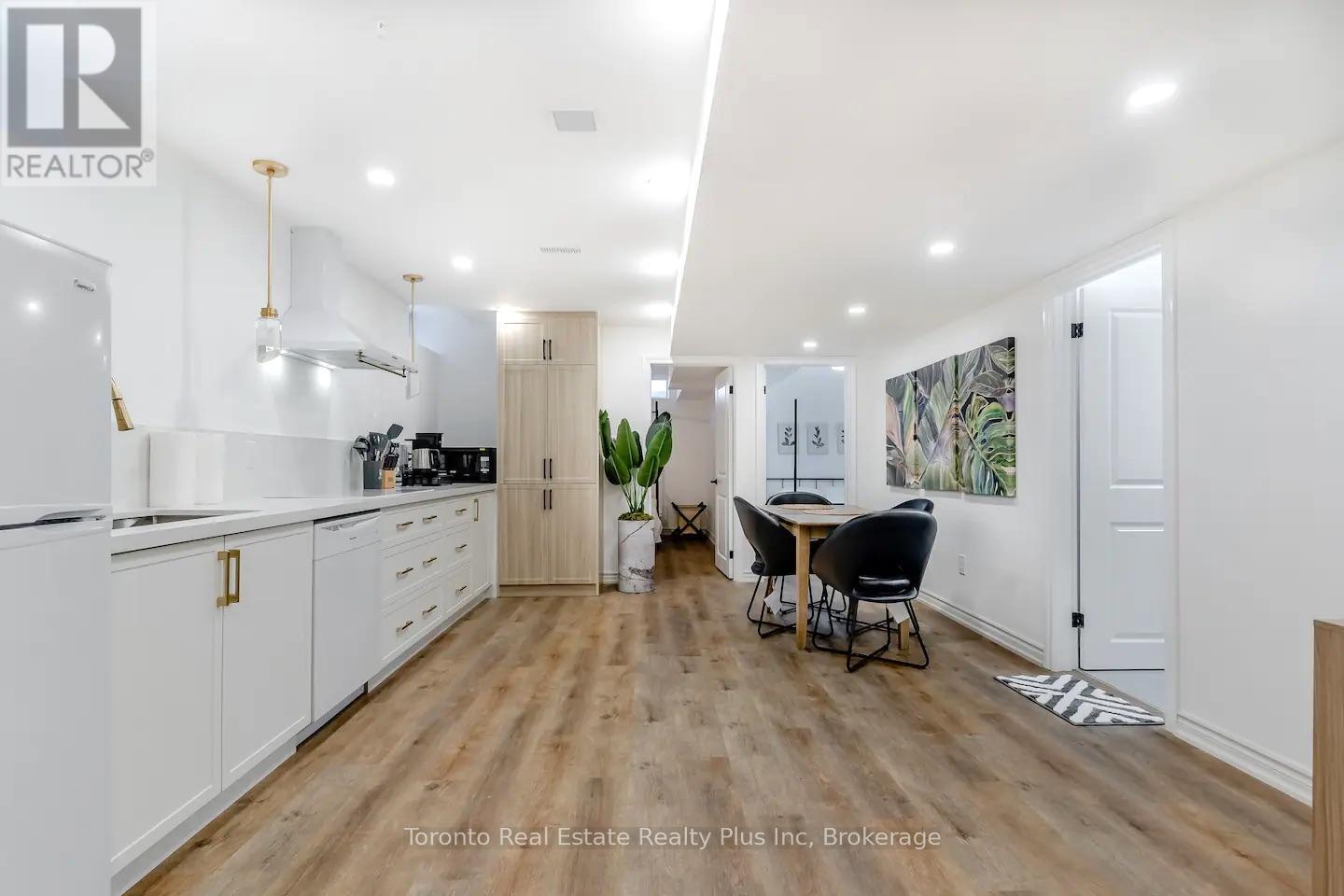 A modern kitchen with white cabinets and a dining area with a table and chairs.
