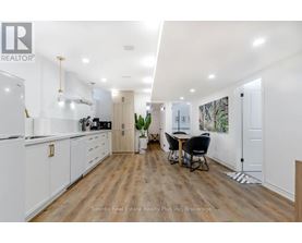 A modern kitchen with white cabinets and a dining area with a table and chairs.