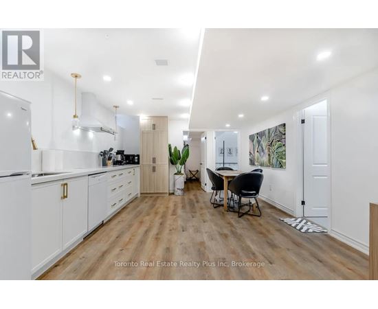 A modern kitchen with white cabinets and a dining area with a table and chairs.