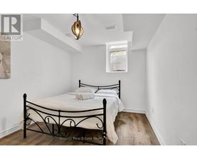 A bedroom with a black metal bed frame and a small window.