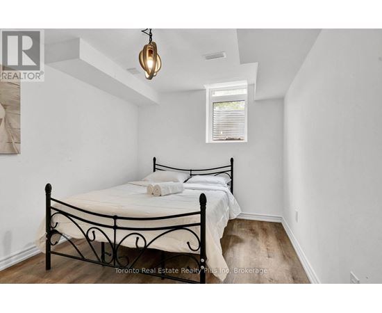 A bedroom with a black metal bed frame and a small window.
