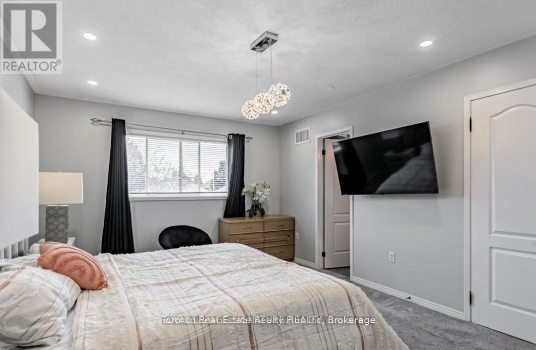 A bedroom with a large bed and a flat screen TV mounted on the wall.