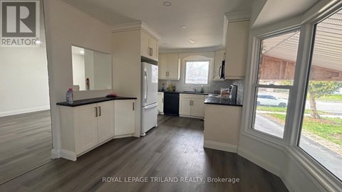 A kitchen with white cabinets and a black countertop.