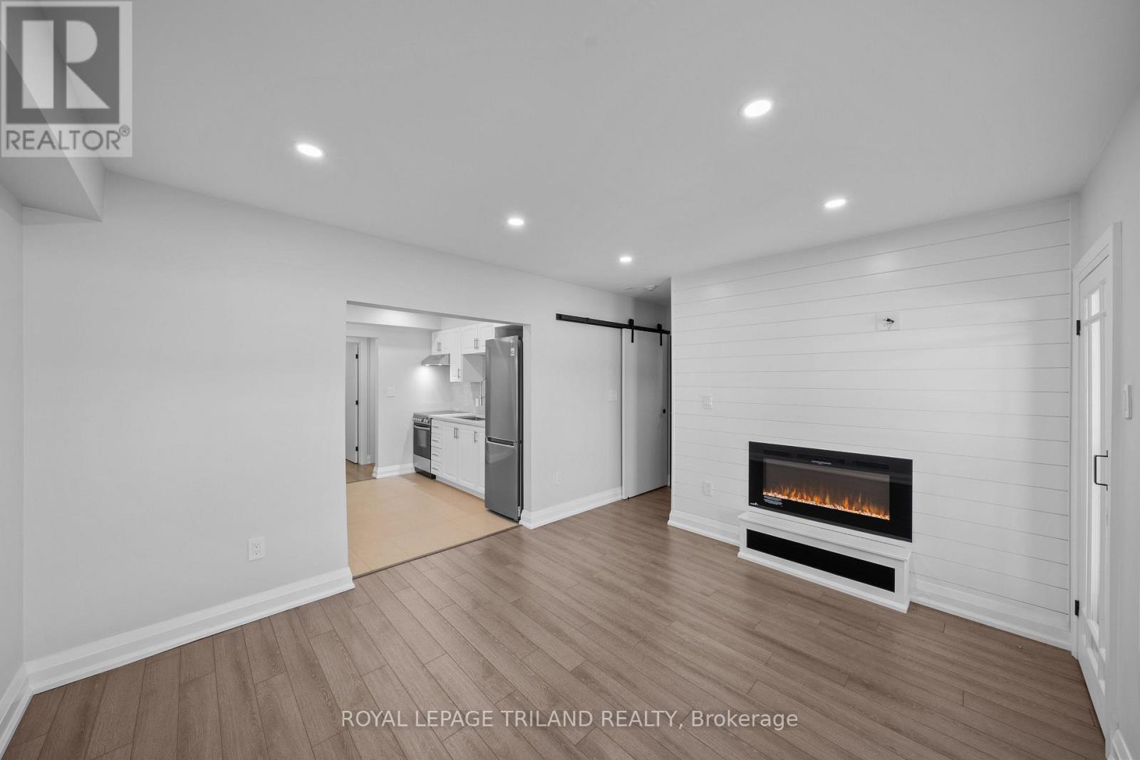 A spacious living room with a fireplace and hardwood floors.