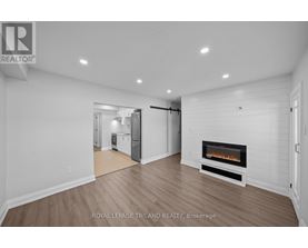 A spacious living room with a fireplace and hardwood floors.