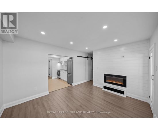A spacious living room with a fireplace and hardwood floors.