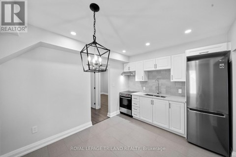 A modern kitchen with white cabinets and stainless steel appliances.