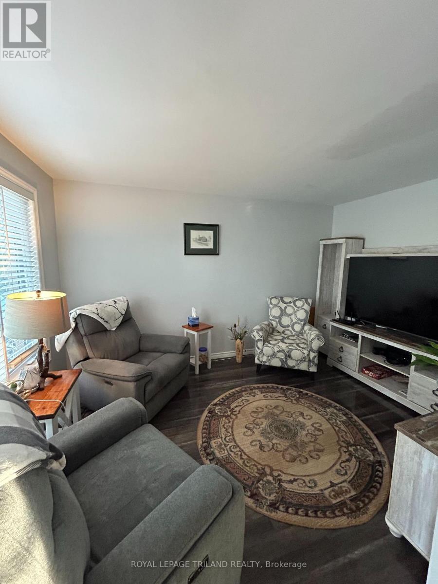 A living room with a grey couch and a rug.