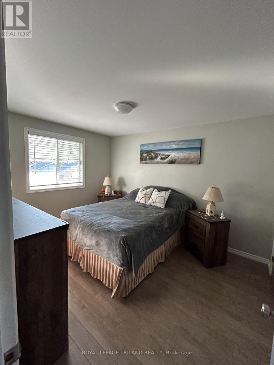 A bedroom with a bed, nightstand, and lamp.