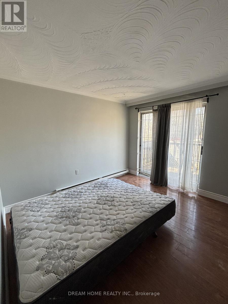 A bedroom with a large bed and a window with curtains.