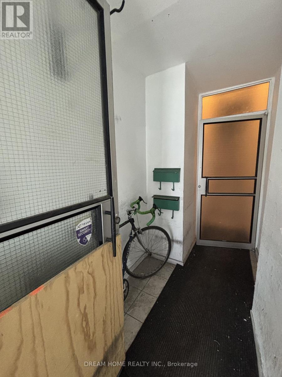 A bicycle is leaning against a wall in a room with a door.