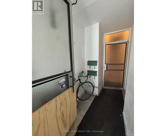 A bicycle is leaning against a wall in a room with a door.