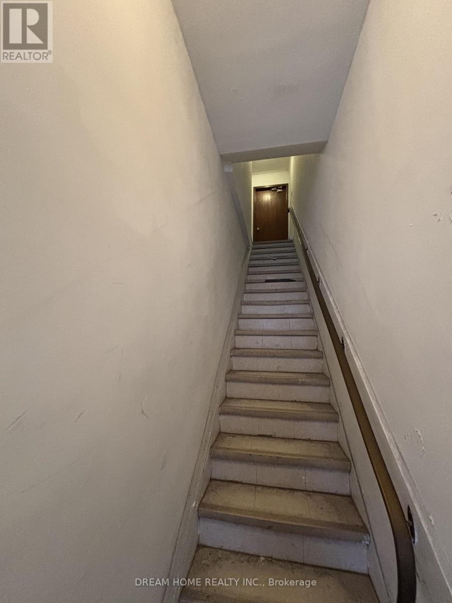A staircase in a building with a logo on the wall.