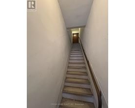 A staircase in a building with a logo on the wall.