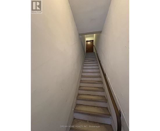 A staircase in a building with a logo on the wall.