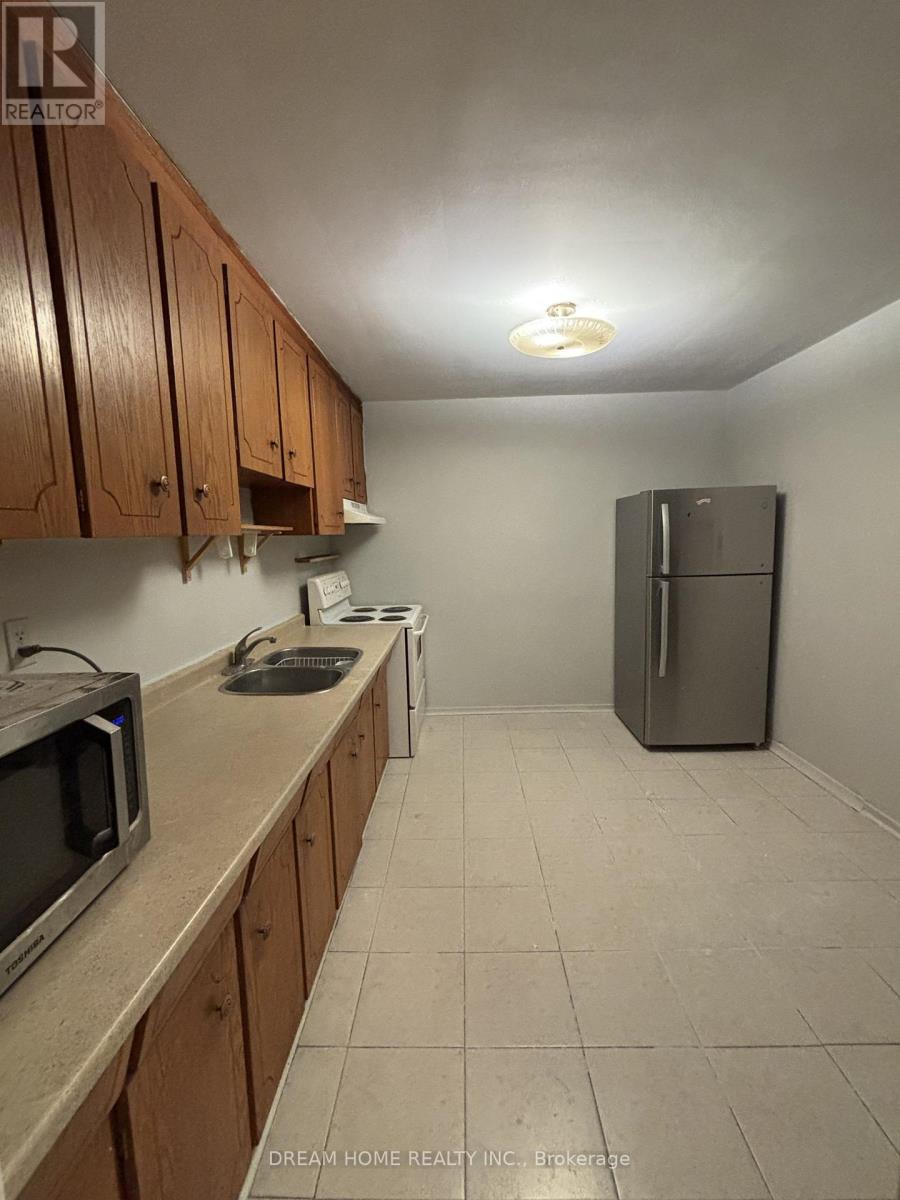 A kitchen with wooden cabinets and a refrigerator.