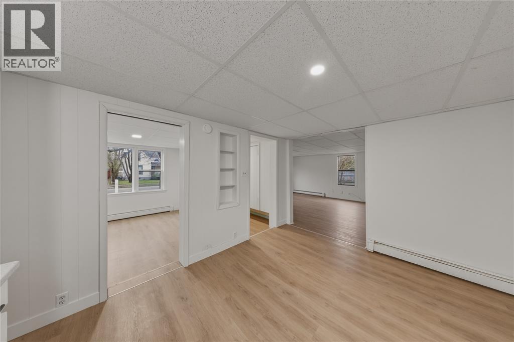 A spacious room with wooden floors and white walls.