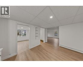 A spacious room with wooden floors and white walls.