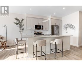 A modern kitchen with white cabinets and a white island with bar stools.