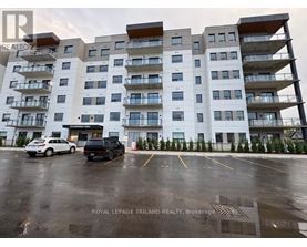 A large white building with balconies and a car parked in front.