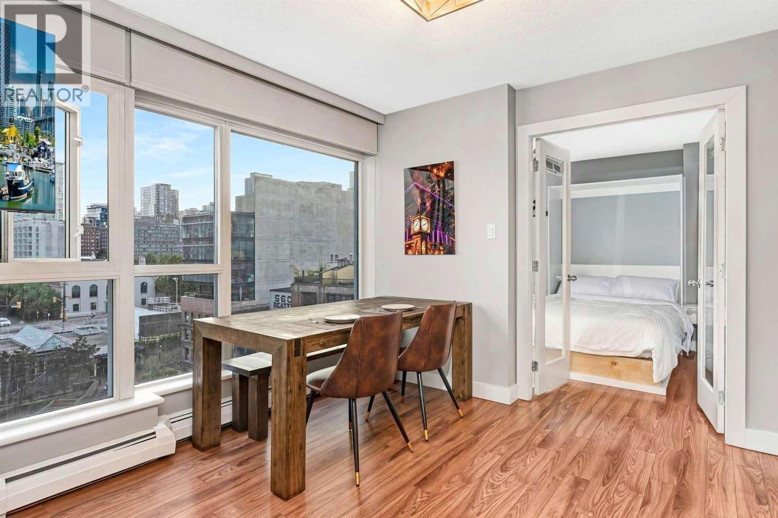 A bedroom with a bed and a table with chairs is shown.