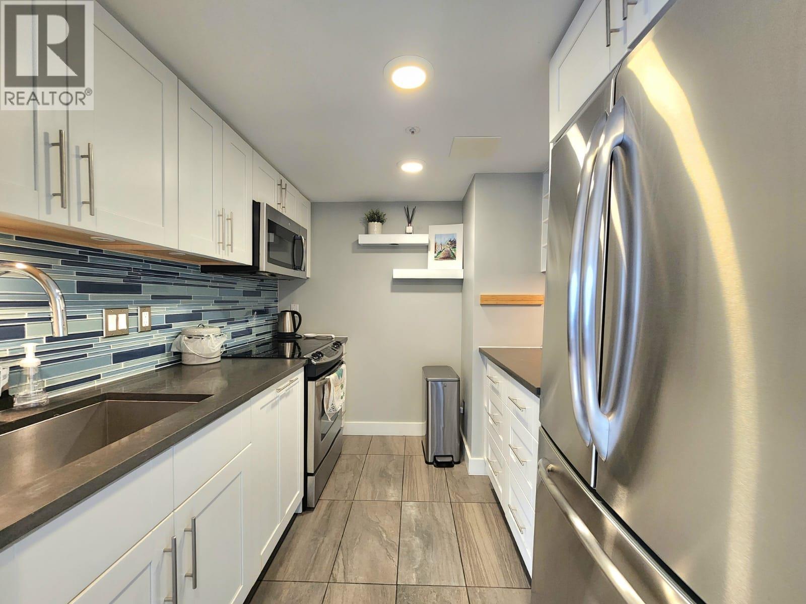 A modern kitchen with a stainless steel refrigerator.