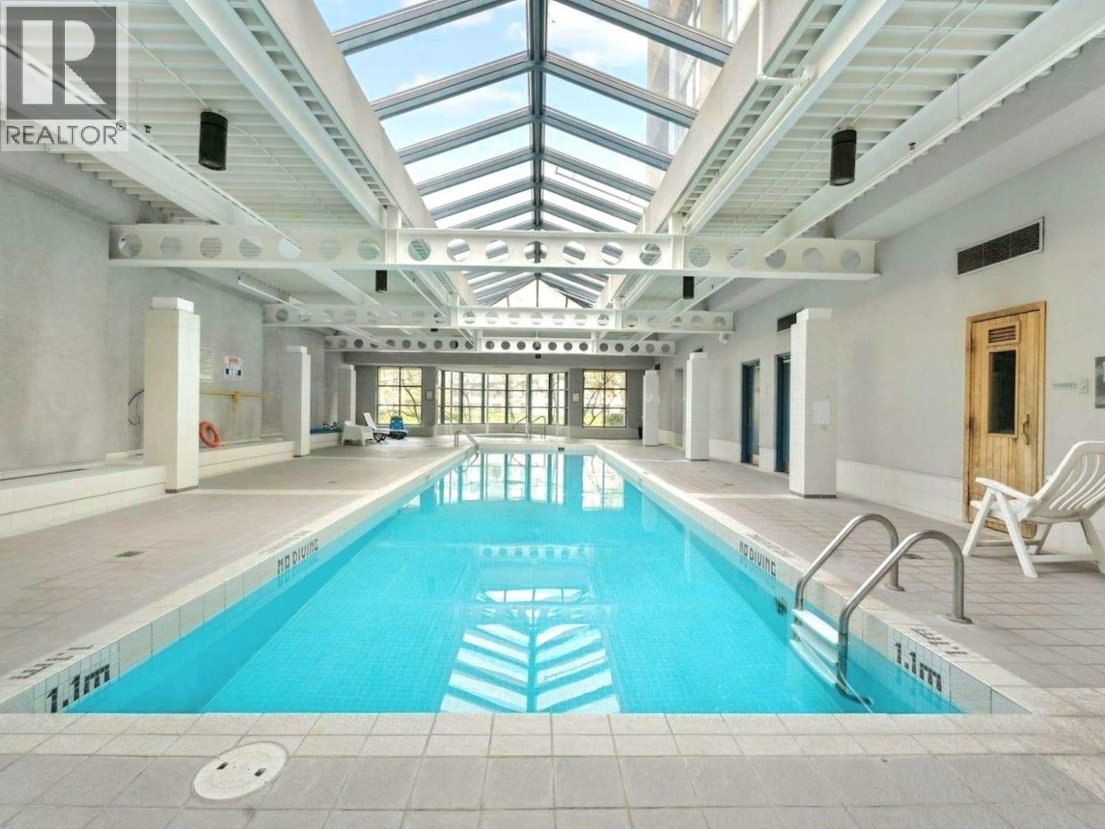 A large indoor swimming pool with a glass ceiling.