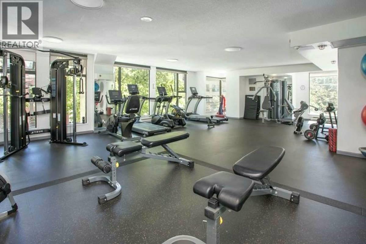 A gym with a variety of equipment including treadmills, weights, and exercise machines.