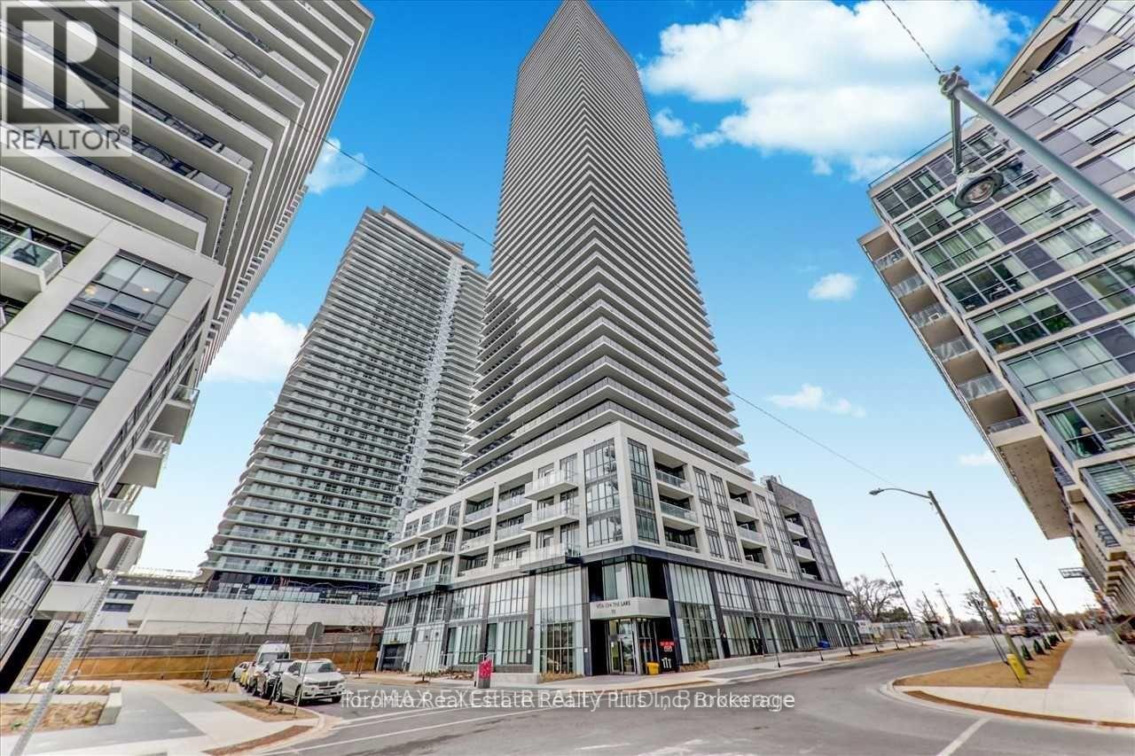A modern building with a curved facade stands in the middle of a city street.
