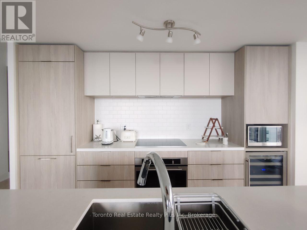 A modern kitchen with a stainless steel oven and white cabinets.