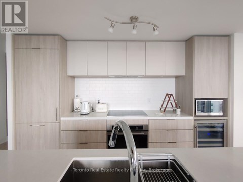 A modern kitchen with a stainless steel oven and white cabinets.