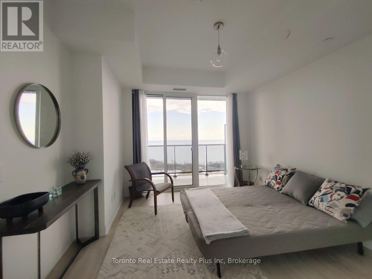 A bedroom with a large bed and a view of the ocean through the window.