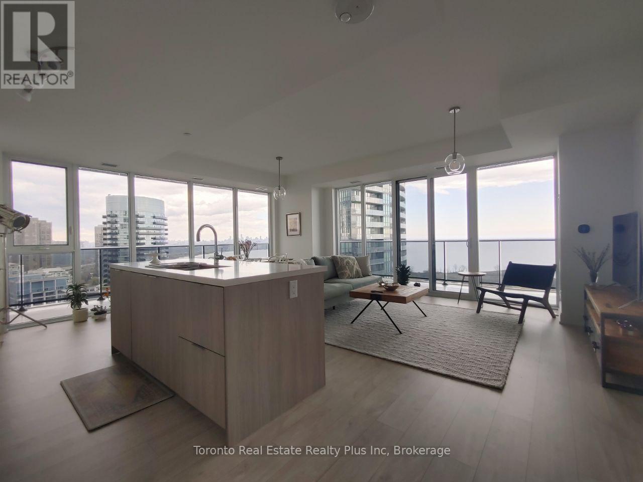 A spacious living room with a large window overlooking the city.