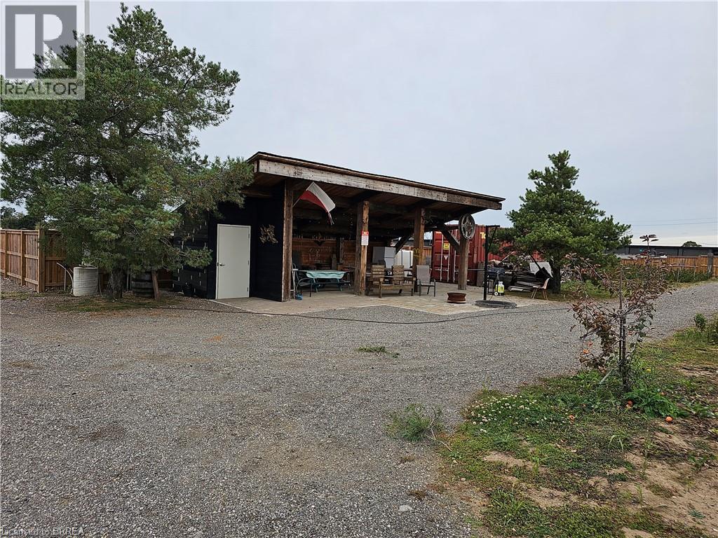 A gravel area with a building and a tree.