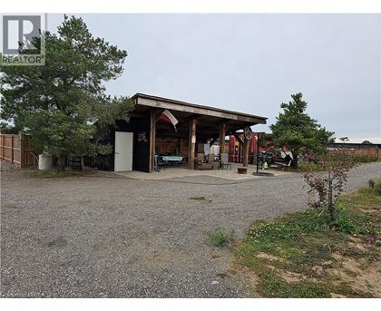 A gravel area with a building and a tree.