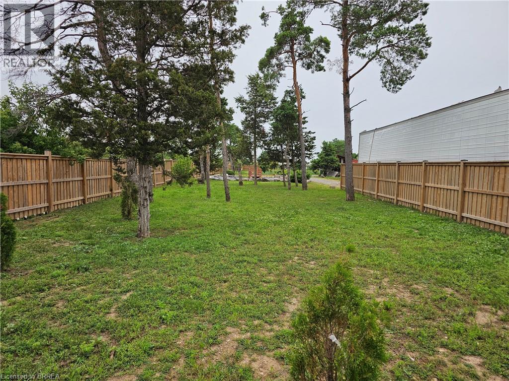 A backyard with a fence and trees.