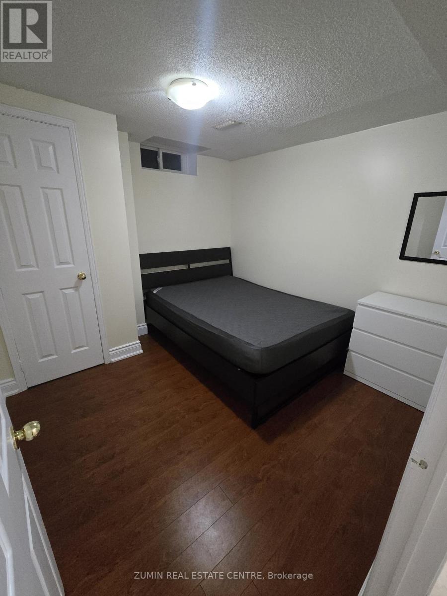 A bedroom with a bed, dresser, and mirror.