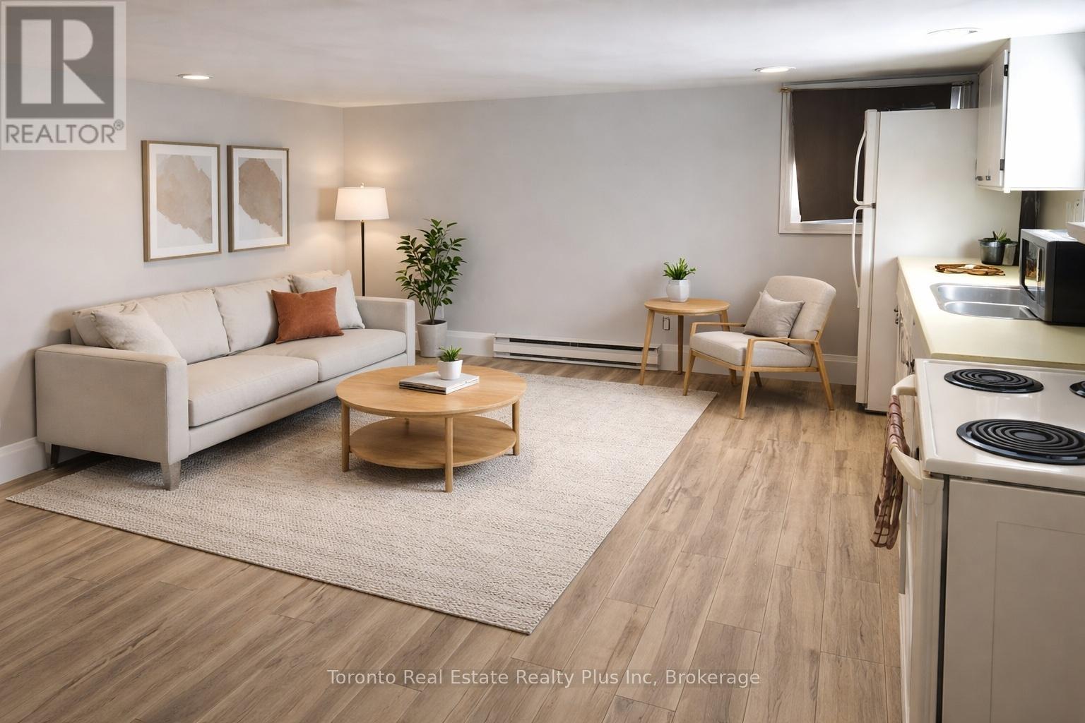 A well-lit, modern living room with a kitchen area in the background.