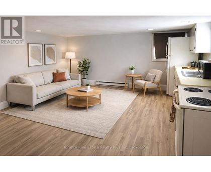 A well-lit, modern living room with a kitchen area in the background.