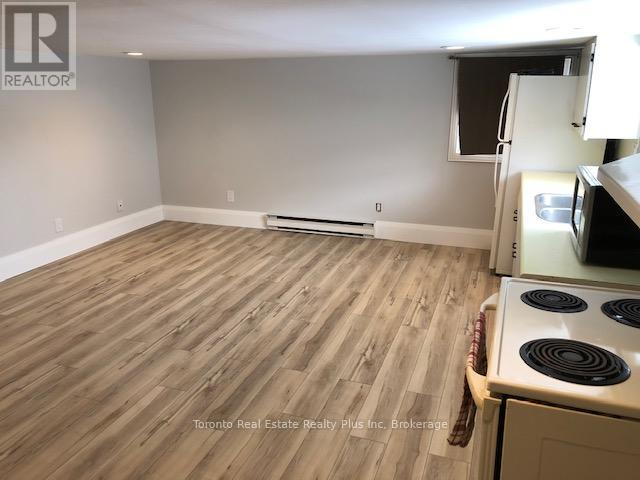 A kitchen with a stove and a refrigerator.