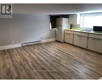 A kitchen with white cabinets and a wooden floor.