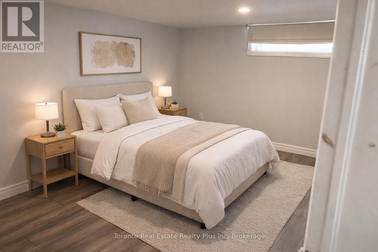 A bedroom with a bed, nightstands, and a rug.