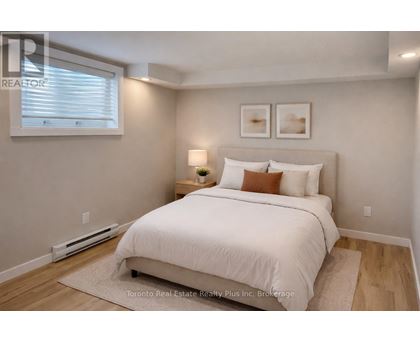 A bedroom with a white bed and a window with blinds.