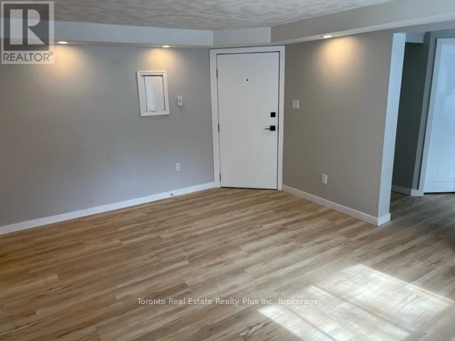 A room with wooden flooring and a white door.