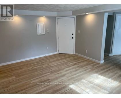 A room with wooden flooring and a white door.