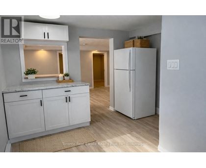 A kitchen with white cabinets and a refrigerator.